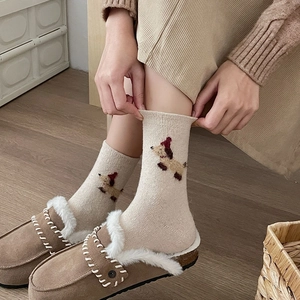 Detail of beige knit socks with cute brown puppy embroidery and warm fuzzy shoes