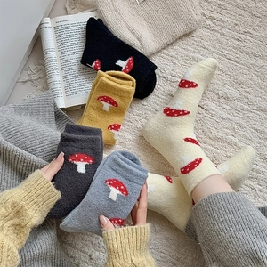 Detail of warm fluffy socks with cute mushroom patterns in five cozy winter colors