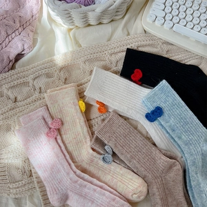 Détails des chaussettes en laine avec petits cœurs crochetés et texture en maille côtelée