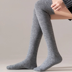 Detail of grey ribbed knit over-the-knee socks showing thick texture and warm fabric