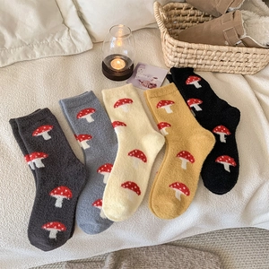 Detailed view of 5 pairs of thick fuzzy socks with mushroom embroidery in warm colors