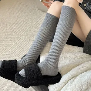 Detailed view of grey knitted knee-high socks with thick vertical ribbed texture