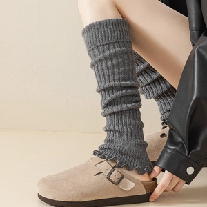 Dettaglio di scaldamuscoli grigi glitterati abbinati a sabot in pelle scamosciata beige