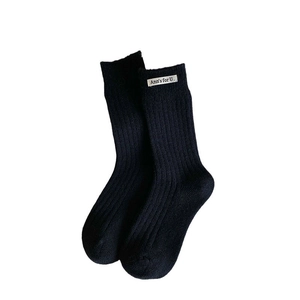Fashionable black ribbed cotton crew socks with white letter patch and elastic texture