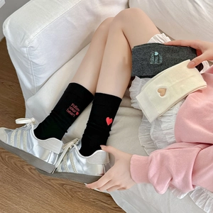 Three pairs of heart embroidered cotton crew socks in black, gray, and cream colors