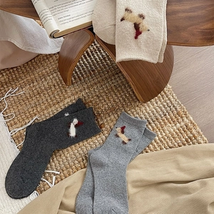 Close-up of thick knitted crew socks with cute puppy embroidery in diverse colors
