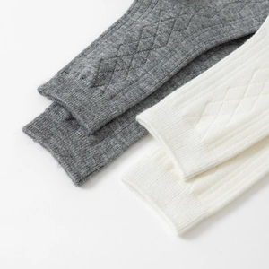 Close-up of thick knit mid-calf socks with classic ribbed texture and diamond pattern