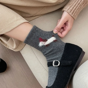 Detail of grey knitted socks with dog embroidery and elastic ribbed cuff texture