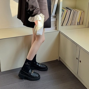Detail of wool socks with shimmering rhinestones and black leather platform loafers