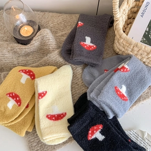 Detail showing plush thermal socks with cute mushroom patterns on soft knit fabric