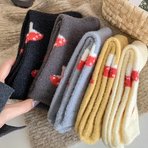 Close-up of soft winter thermal socks with cute red mushroom patterns in five colors