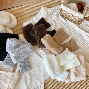 Flat lay of colorful faux fur leg warmers with knitted cuffs in various seasonal shades