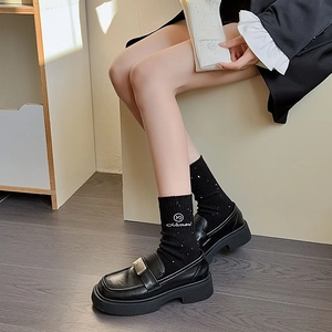 Detail of wool socks with rhinestones and Mina embroidery worn with black loafers