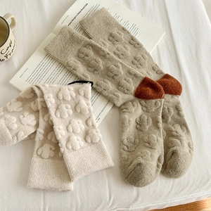 Detailed view of vintage wool socks with embossed floral patterns and contrast heel design