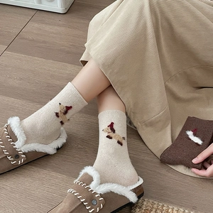 Detailed embroidery of a cute puppy wearing a red hat on beige warm cotton socks