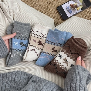 Texture a maglia dettagliata di calze di lana con graziosi motivi di cani e fiocchi