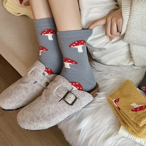 Detail of warm grey knit socks with cute mushroom embroidery and felt buckle mule shoes