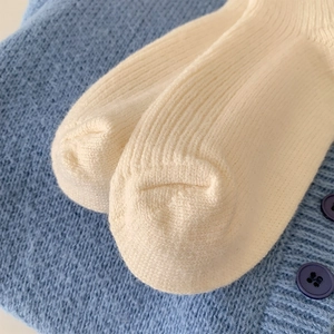 Detailed close-up of cream ribbed knit cashmere socks showing texture and toe seam