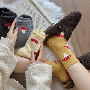 Detailed knit texture of warm winter socks with a cute red mushroom jacquard pattern