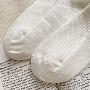Close-up of white ribbed knit wool socks showing high-quality seamless toe stitching
