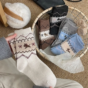 Dettaglio della trama in maglia di calze di lana spesse con motivi Fair Isle e fiocchi