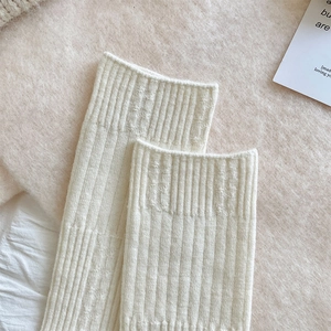 Detailed close-up of cream white ribbed knit socks with thick wool texture and soft fabric