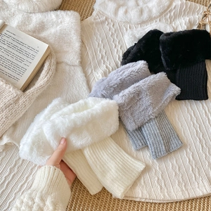 Detail of furry knit leg warmers in white, grey, and black colors for winter styling