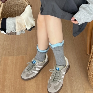 Detail of Japanese style color-block cotton crew socks with frilly lace cuffs and bows