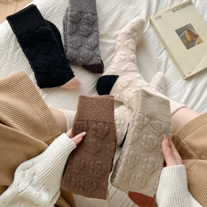Detailed view of thick wool socks with 3D floral textures and contrast heel design