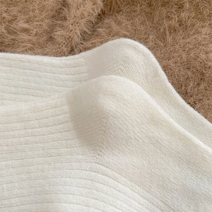Detailaufnahme weißer Wollsocken mit Rippstrickmuster und weicher Plüschtextur