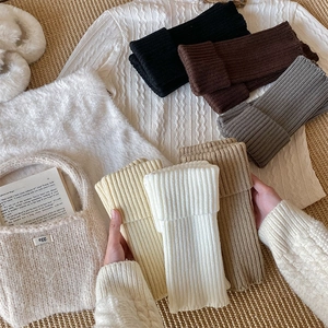 Macro shot of thick ribbed knit leg warmers in various colors like black and khaki