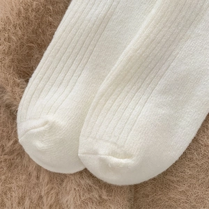 Makrodetail weißer gerippter Wollsocken mit dicker warmer Textur und vertikalen Streifen
