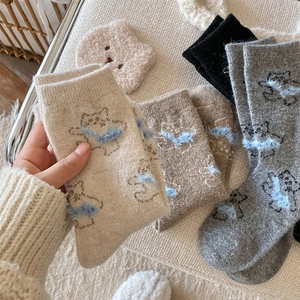 Close-up of thick knit wool socks featuring cute bear patterns and 3D plush details