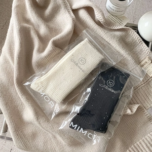 Close-up of black and beige wool socks with rhinestone details in Mimor packaging