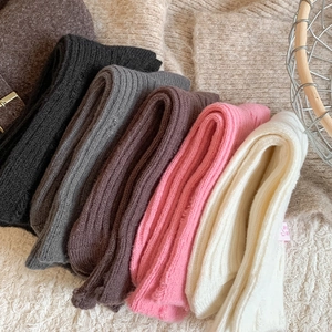 Macro detail of thick ribbed cashmere socks in assorted neutral and pastel winter colors
