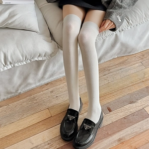 Détail de chaussettes hautes blanches tricotées avec bords-côtes et tissu extensible