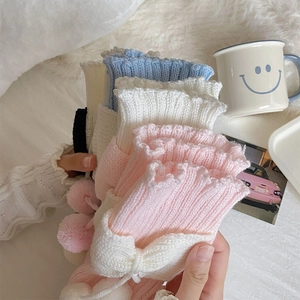 Détails des jambières Lolita en maille avec bords à volants et pompons aux tons pastel