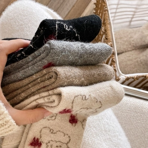 Detailed close-up of thick winter wool socks with cute cartoon bear and heart patterns