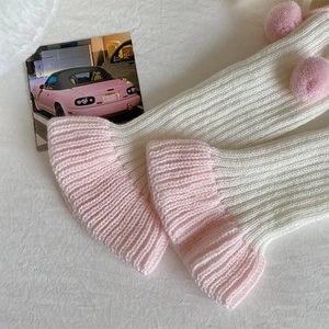 Détail de jambières Lolita roses et blanches avec pompons doux et texture en maille côtelée