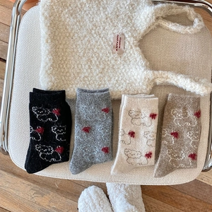 Flat lay of thick wool socks in four colors with cute dog patterns and red hearts