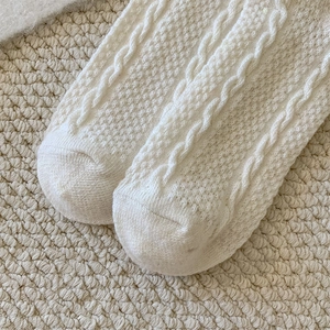 Close-up of white cable-knit texture and breathable stitch details on warm wool socks