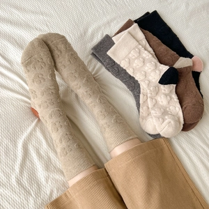 Detailed view of winter wool socks featuring 3D embossed cartoon patterns and warm textures