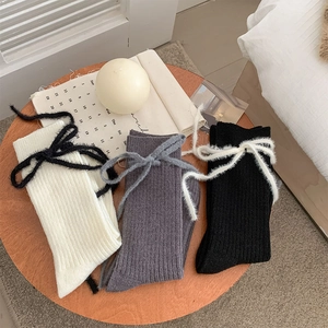 Drei Paar dicke Rippstrick-Socken mit Plüschschleifen in Creme, Grau und Schwarz Tönen
