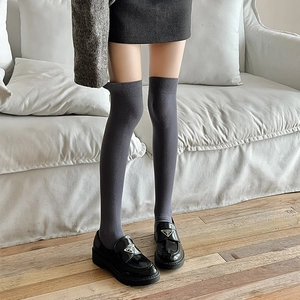Gros plan de chaussettes hautes gris foncé montrant la maille fine et les bords côtelés