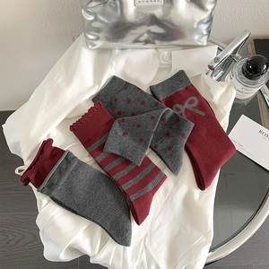 Flat lay of vintage burgundy bow socks and striped patterns with fashion accessories