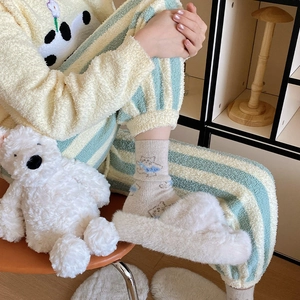 Detail of warm winter fluffy socks featuring blue cartoon bear pattern and soft wool texture
