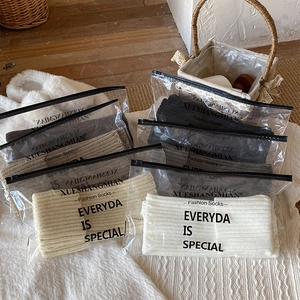 Close-up of ribbed knit leg warmers in various colors with zipper packaging bags