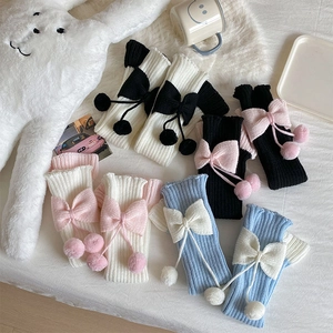 Détail de jambières en tricot Lolita avec nœuds doux et pompons en peluche pour l'hiver
