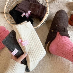 Close-up of ribbed knit cashmere socks with distressed holes and heart woven labels