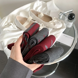 Close-up of soft knitted socks in burgundy and grey with romantic heart patterns